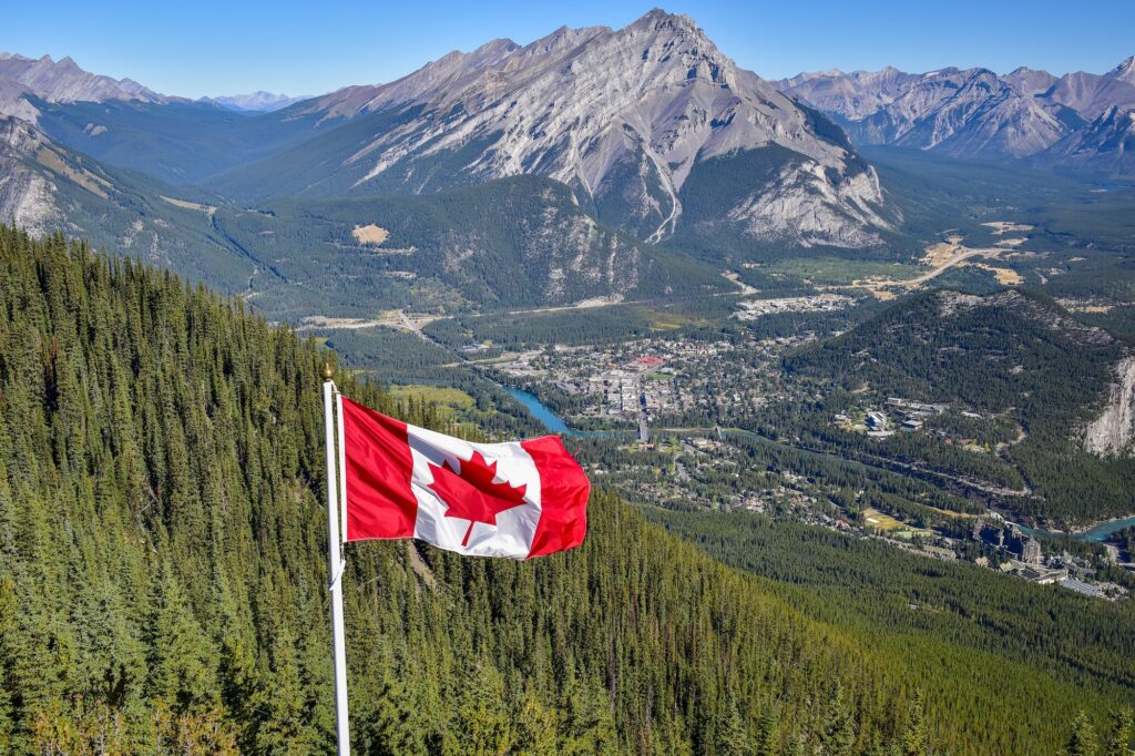 Canada flag with Canadian rocky mountain at the background