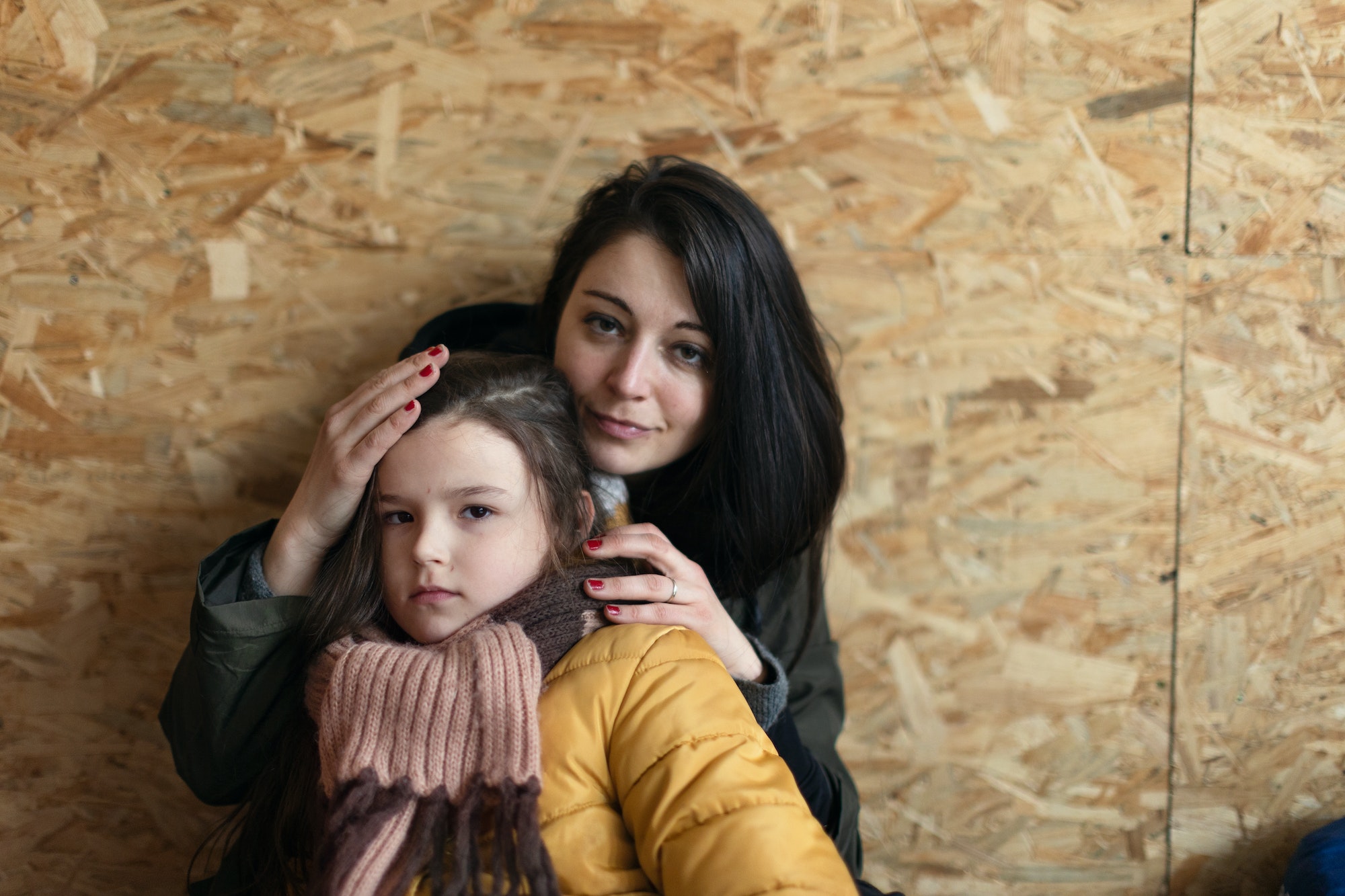 Ukrainian war refugees in temporary shelter and help center, little girl with her mother